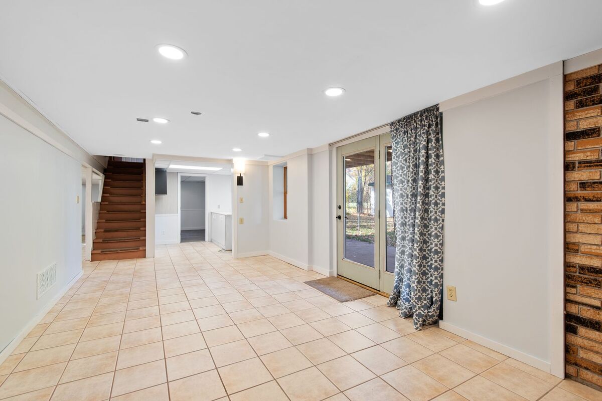 Finished walkout basement lit by evenly spaced LED pot lights