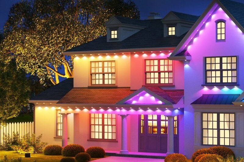 Two-storey house at night with colour-changing permanent lights under the eaves
